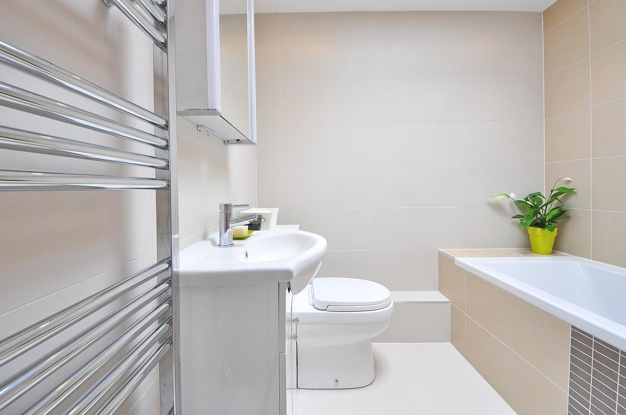 A small white bathroom with a toilet, basin and towel rail